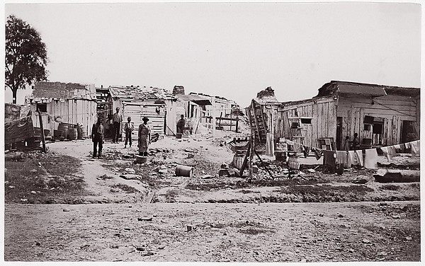 [Encampment with shacks and laundry]